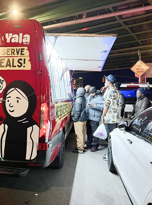 Volunteers serving meals from the Hope Bus.